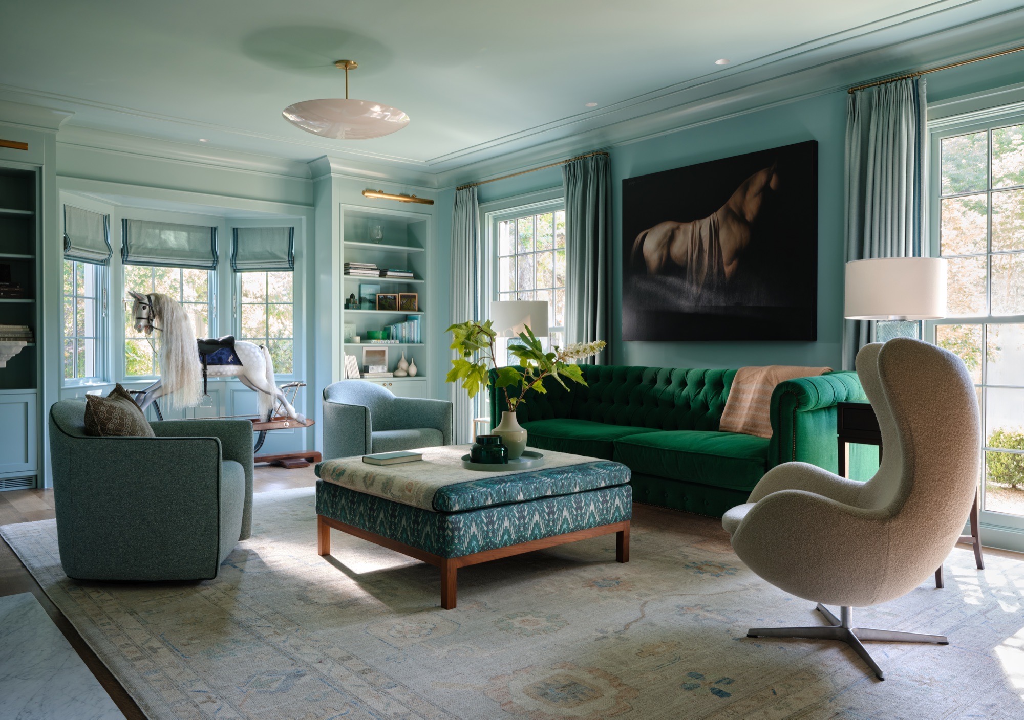 Blue living room with built-in shelves and garden windows in an Austin Colonial Revival house