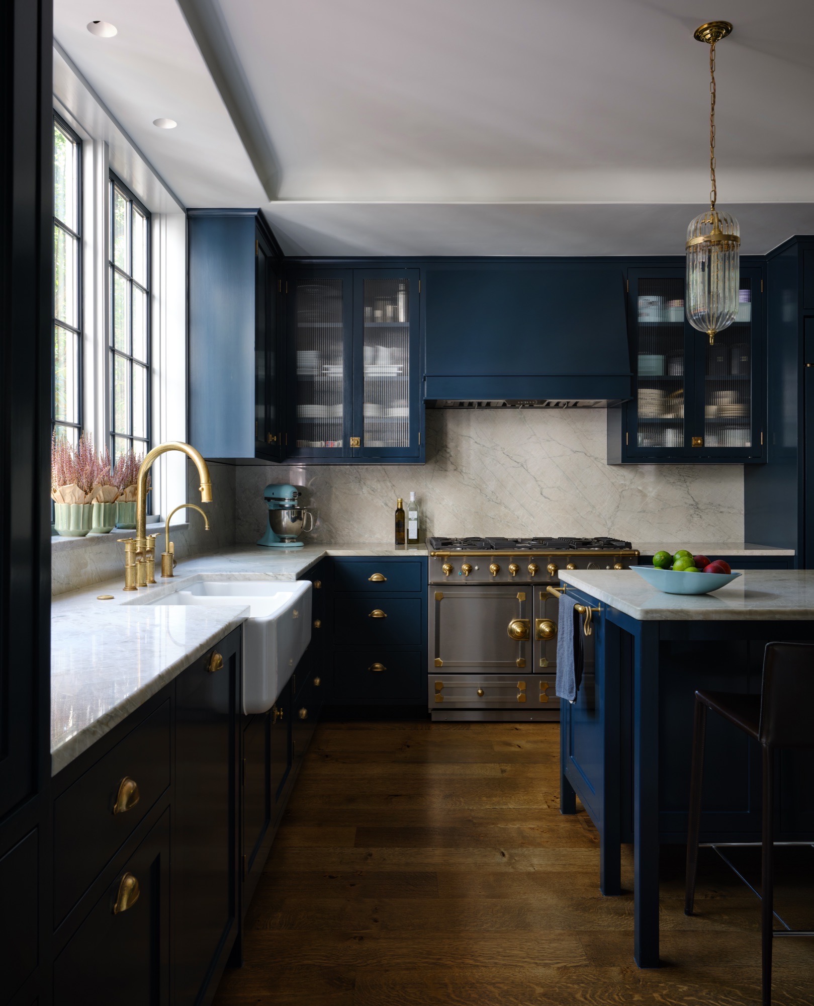 Navy kitchen with marble counters and brass fixtures in an Austin historic house