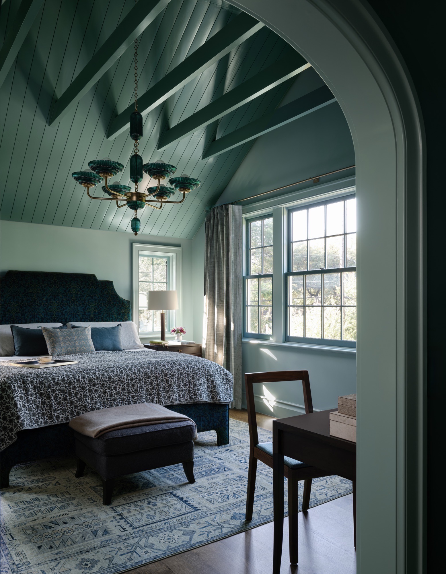 Vaulted bedroom with painted beams and arched opening in an Austin Colonial Revival house