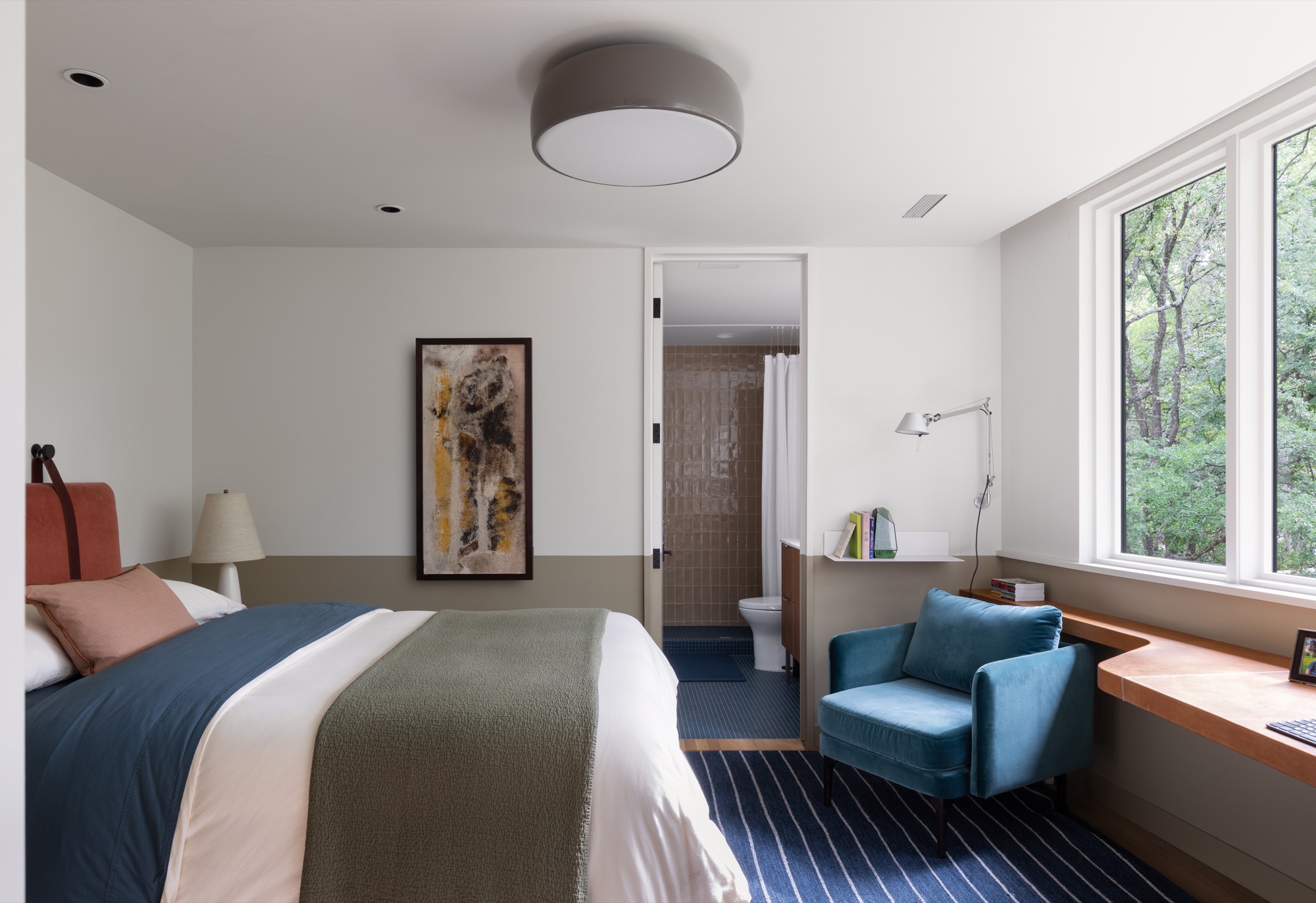 Bedroom of a modern Austin house with a custom leather desk looking into the bathroom