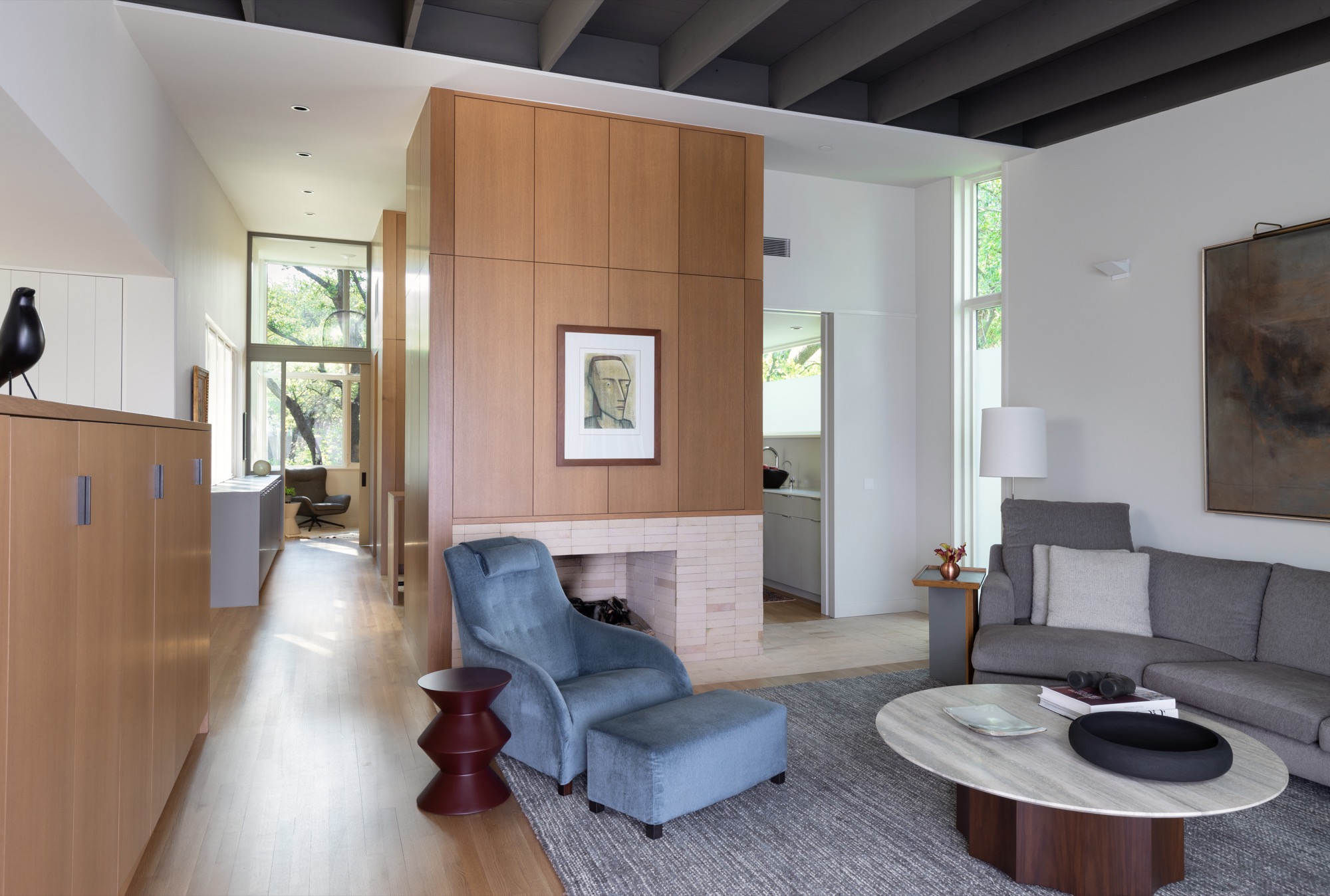 Living room of a modern Austin house centered on a wood fireplace volume