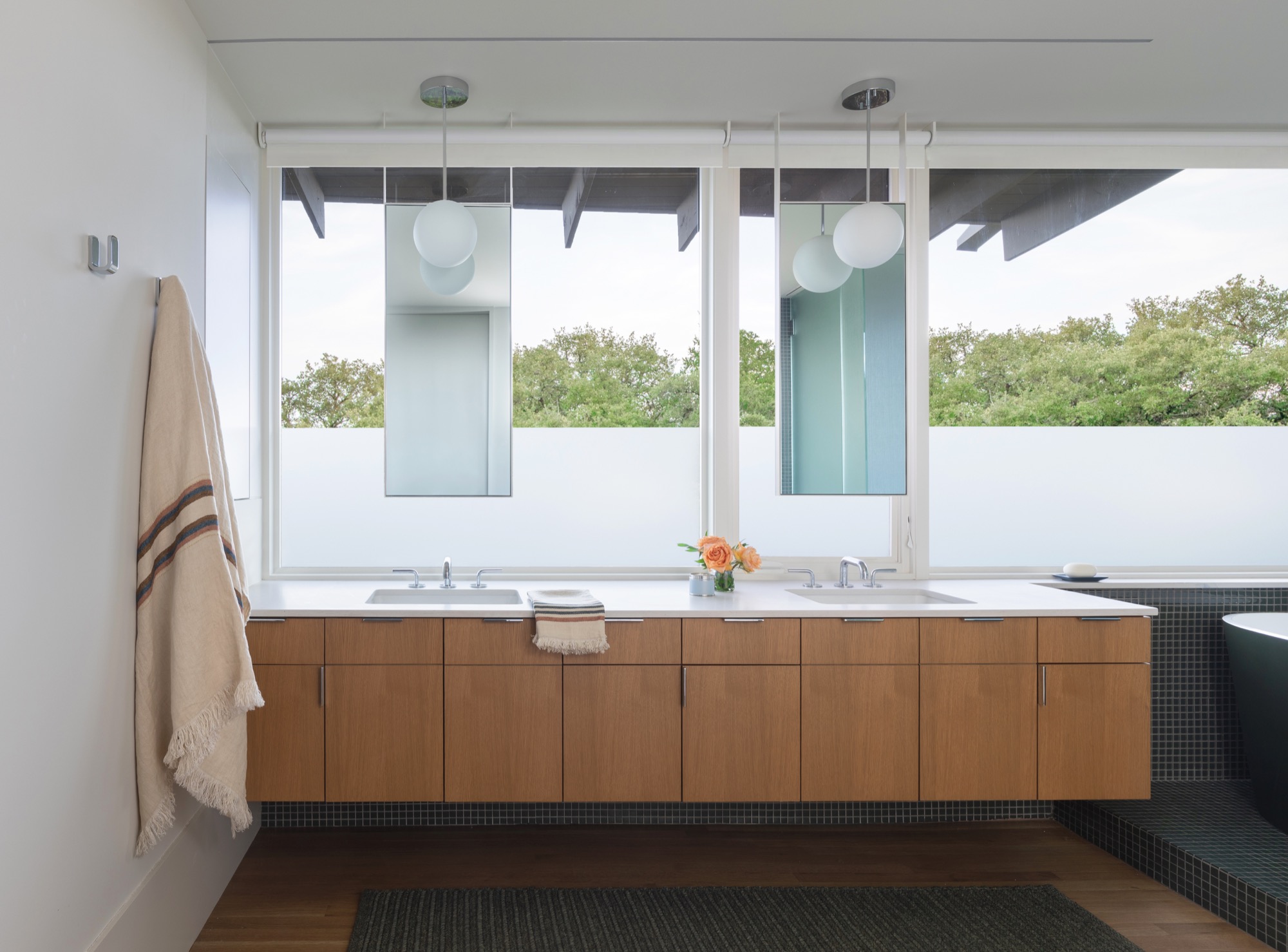 Bathroom of a modern Austin house with a long double vanity and white oak cabinetry