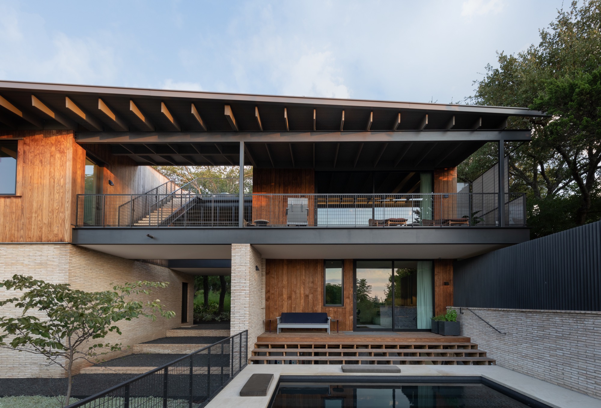 Modern Austin home with courtyard, pool, and elevated terrace connecting indoor and outdoor living